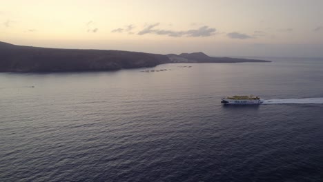 Canary-Islands-Ferry-Lines,-Aerial-View-of-Fred,-Olsen-Ship-Sailing-by-Tenerife-Island-Coastline-in-Twilight,-Spain