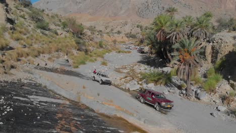 Vista-Aérea-De-Los-Todoterrenos-Que-Cruzan-El-Arroyo-En-El-Terreno-De-Baluchistán