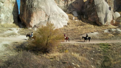 Tourists-Riding-Horses-With-Guide-At-Goreme-National-Park-In-Cappadocia,-Turkey