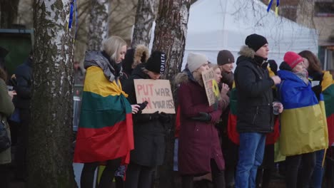 Two-Girls-Standing-in-Protest-Gathering-in-Vilnius-with-Lithuanian-Flag-and-Sign-Against-War