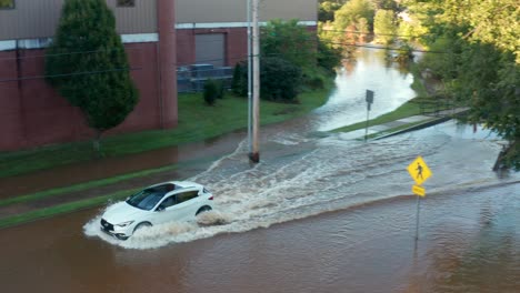 Weißes-Auto-Fährt-In-überflutetes-Straßenwasser