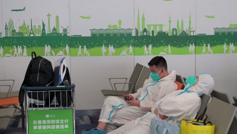 Passengers-wearing-personal-protective-equipment-suits-wait-to-board-their-flights-at-Chek-Lap-Kok-International-Airport-in-Hong-Kong,-China