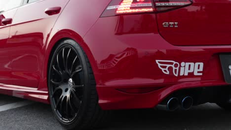 Close-up-of-hot-rod-red-Volkswagon-GTi-with-modified-exhaust-car-parked-in-a-car-park