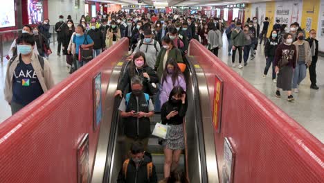 Se-Ve-A-Cientos-De-Personas-Viajando-En-Escaleras-Automáticas-En-Movimiento-En-Una-Estación-De-Metro-Mtr-Llena-De-Gente-En-Hong-Kong