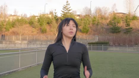 Junger-Asiatischer-Athlet-Mit-Hohen-Knien-Und-Armen-Trainiert-Mittlere-Aufnahme