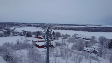 Aerial-snow-covered-radio-tower-during-a-winter-day