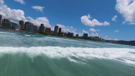 Chasing-Waves-in-Waikiki,-Slow-Motion-FPV-Drone-over-Pacific-Ocean-Looking-Towards-Honolulu-and-Diamond-Head