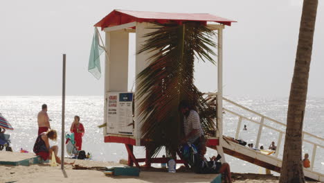 Beachgoers-by-Lifeguard-Shack-on-San-Juan-Beach-in-Puerto-Rico,-Static