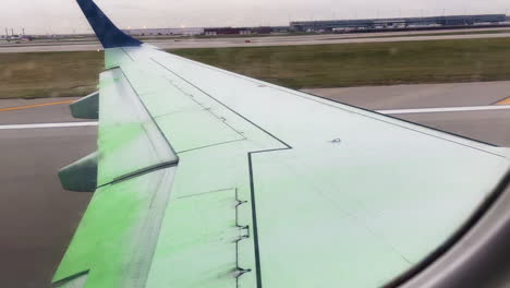 Plane-Takes-Off-From-Airport-Runway-With-Green-De-Icing-Liquid-Dripping-Off-Wing