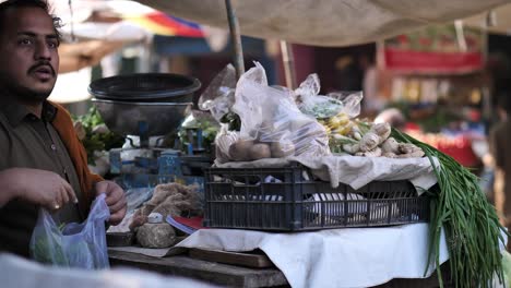 Vendedor-Del-Mercado-Colocando-Verduras-En-Bolsas-En-El-Mercado-Del-Bazar-Saddar-En-Karachi