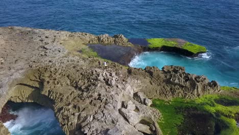 Erstaunlicher-Luftbildflug,-Rückwärts-Fliegen,-Langsam-Nach-Oben-Kippen,-Drohnenschuss,-Große-Meereswellen,-Die-Gegen-Die-Felsen-Von-Devil&#39;s-Tear-Am-Lembongan-Rock-Cliff-Beach-Am-Mittag-Auf-Bali-2017-Krachen