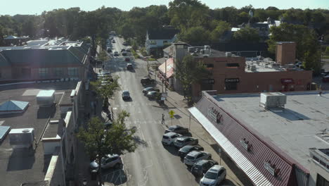 Aerial-tracking-shot-of-a-vehicle-braking-heavily-for-a-pedestrian-who-hastily-walks-into-the-road-on-a-marked-crosswalk,-Naperville,-Chicago,-Illinois