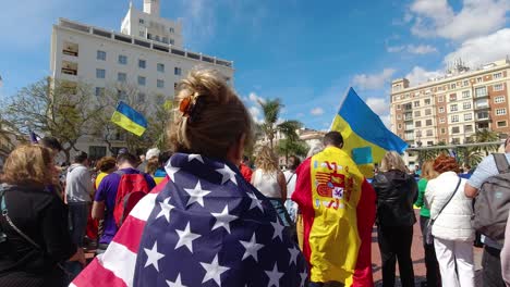 Woman-wearing-USA-flag-during-anti-war-protests-of-Ukraine-and-Russia-Slow-motion-view