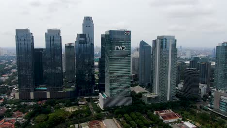 Tall-glass-skyscrapers-in-Jakarta-city,-aerial-drone-flying-towards-FWD-tower