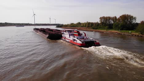 Aerial-View-Over-Veerhaven-Pushtow-Ship-Transporting-Empty-Barges-Along-Oude-Maas