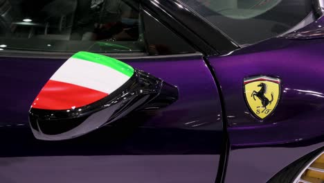 Italian-luxury-sport-car-manufacturer,-Ferrari-logo-and-Italian-flag-painted-on-the-mirror-seen-on-a-GT-Ferrari-458-luxury-supercar-during-the-International-Motor-Expo-in-Hong-Kong