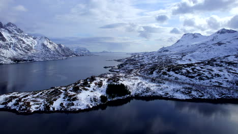 Panoramic-Aerial-view-towards-Austnesfjorden-rest-area,-with-scenery-winter-landscape,-Lofoten,-Norway,-E10