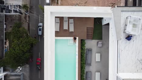drone-view-showing-girl-in-bikini-enjoying-beautiful-empty-pool
