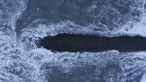 Basalt-rock-barrier-hit-by-powerful-waves-of-the-Atlantic-ocean---Aerial-straight-down