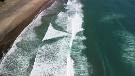 Vertical-pan-from-drone-over-Piha-black-sand-beach-in-NZ