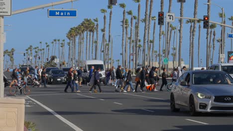 Eine-Menschenmenge-überquert-Den-Pacific-Coast-Highway-In-Huntington-Beach,-Kalifornien