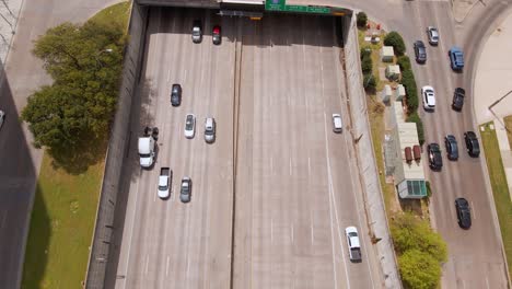 Aerial-view-overlooking-traffic-on-the-Texas-State-Highway-Spur-366,-revealing-the-Klyde-Warren-Park,-in-Dallas,-USA---tilt,-drone-shot