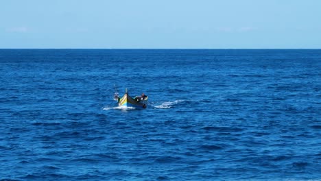 Lonely-person-sailing-in-high-motor-wooden-boat-near-Malta-coastline