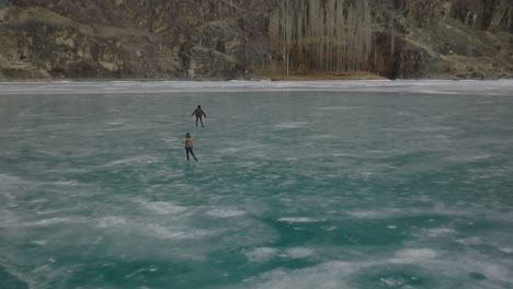 Viele-Leute-Gehen-Draußen-Auf-Den-Zugefrorenen-See,-Um-Schlittschuh-Zu-Laufen