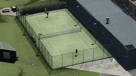 Trainer-Und-Tennisspieler-üben-Verschiedene-Schläge-Auf-Dem-Rasentennisplatz