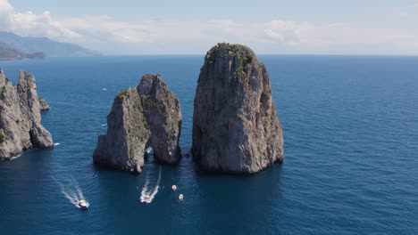Boats-Exploring-Famous-Travel-Destination---The-Faraglioni-Rocks,-Italy