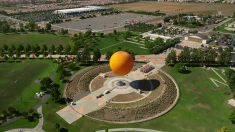 Vista-Aérea-Circular-Del-Paseo-En-Globo-Naranja-En-El-Gran-Parque,-Irvine,-California