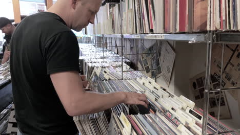 Male-Looking-and-Browsing-through-Vinyl-Records-at-a-Record-Store