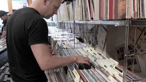 Macho-Mirando-Y-Hojeando-Discos-De-Vinilo-En-Una-Tienda-De-Discos