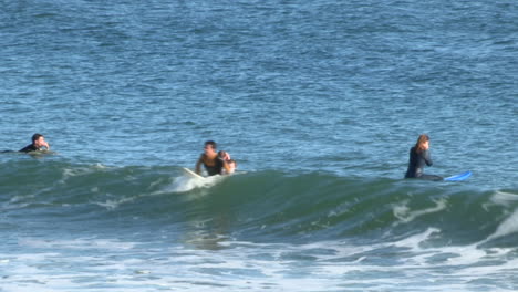 Los-Surfistas-Intentan-Atrapar-Las-Olas,-Con-El-Mar-Todavía-En-Calma