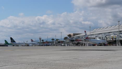 Aviones-Estacionados-En-La-Puerta-Y-Rodando-En-El-Aeropuerto-Soleado