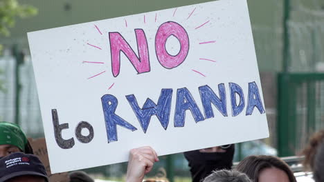 Ein-Handgefertigtes-Pappplakat-Mit-Der-Aufschrift-„Nein-Zu-Ruanda“-Wird-Hochgehalten,-Um-Gegen-Den-Ersten-Flug-Nach-Ruanda-Zu-Protestieren,-Mit-Dem-Migranten-Abgeschoben-Werden-Sollten,-Die-Von-Der-Regierung-Als-Illegal-Erachtet-Werden