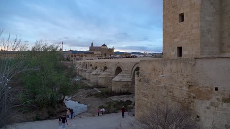 Gente-Disfrutando-Del-Paseo-Nocturno-En-Córdoba,-España-Con-Mezquita-En-Segundo-Plano