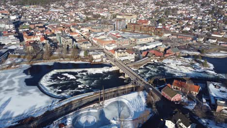 Puente-De-La-Ciudad-De-Kongsberg-Que-Conecta-La-Ciudad-Sobre-El-Río-Numedalslagen-En-Noruega---Hermosa-Antena-Soleada-Por-La-Mañana-Con-El-Río-Que-Fluye-Y-El-Tráfico-Que-Pasa-Por-Las-Carreteras