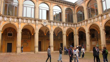 Touristen-Erkunden-Wunderschöne-Alte-Architektur-Und-Kunst-Des-Archiginnasio-Von-Bologna-In-Italien---Schwenkaufnahme