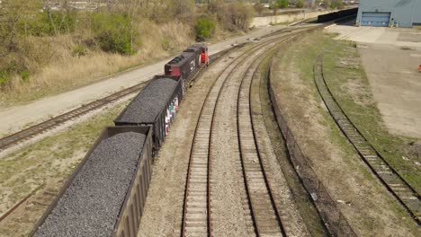 Diesel-locomotive-hauling-carts-filled-with-coal,-aerial-view