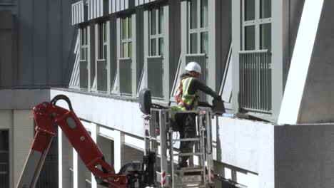 Construction-Worker-In-Cherry-Picker-Working-At-New-Apartments-At-Millbank-In-Westminster