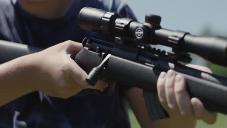 Close-Up-Of-Boy-Firing-Bolt-Action-Rifle