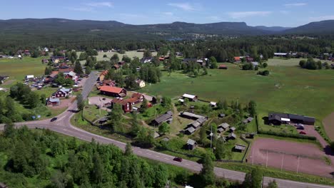 Idyllic-Swedish-country-side-with-old-houses-and-mountains-in-the-background-on-a-sunny-midsummer-day