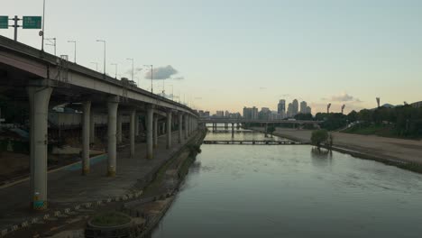 Concrete-columns-under-Dongbu-Expressway,-Cheongdamgyo-2-and-Bongeungyo-bridges-with-a-distant-view-of-Apartments-by-Han-river,-South-Korea