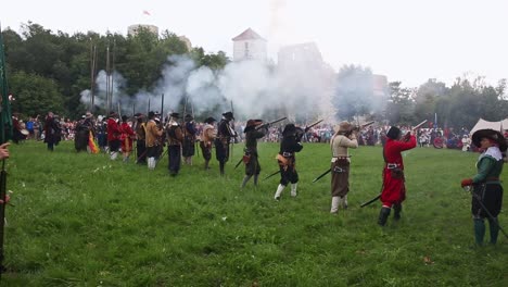 Grupo-De-Soldados-De-Infantería-Disparando-Mosquetes-Durante-La-Recreación-De-La-Batalla-En-El-Castillo-De-Tenczyn,-Polonia