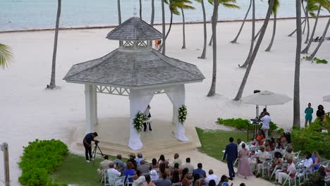 Mother-of-bride-walks-down-wedding-aisle-with-guests-at-outdoor-tropical-resort-wedding
