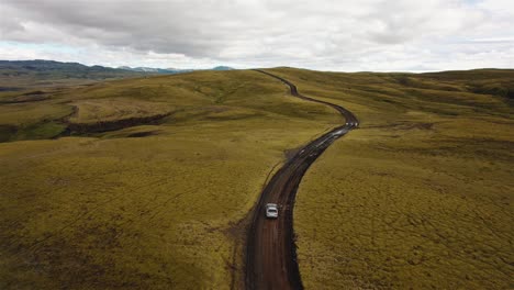 Drone-Siguiendo-Un-Coche-Plateado-En-Un-Camino-De-Tierra-De-Islandia-En-4k
