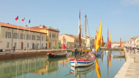 Toma-Panorámica-Del-Museo-De-Barcos-En-El-Porto-Canale-Leonardesco-De-Cesenatico,-Emilia-Romagna,-Italia-Con-Turistas-Caminando-Durante-El-Día