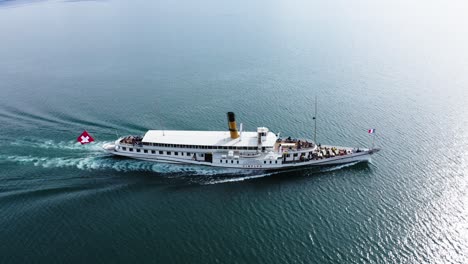 Medium-drone-shot-of-passenger-paddle-steamer-boat-transporting-passengers-across-a-lake-in-Switzerland
