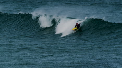 Surfer-Reitet-Meereswelle-Auf-Gelbem-Brett,-Fernsicht
